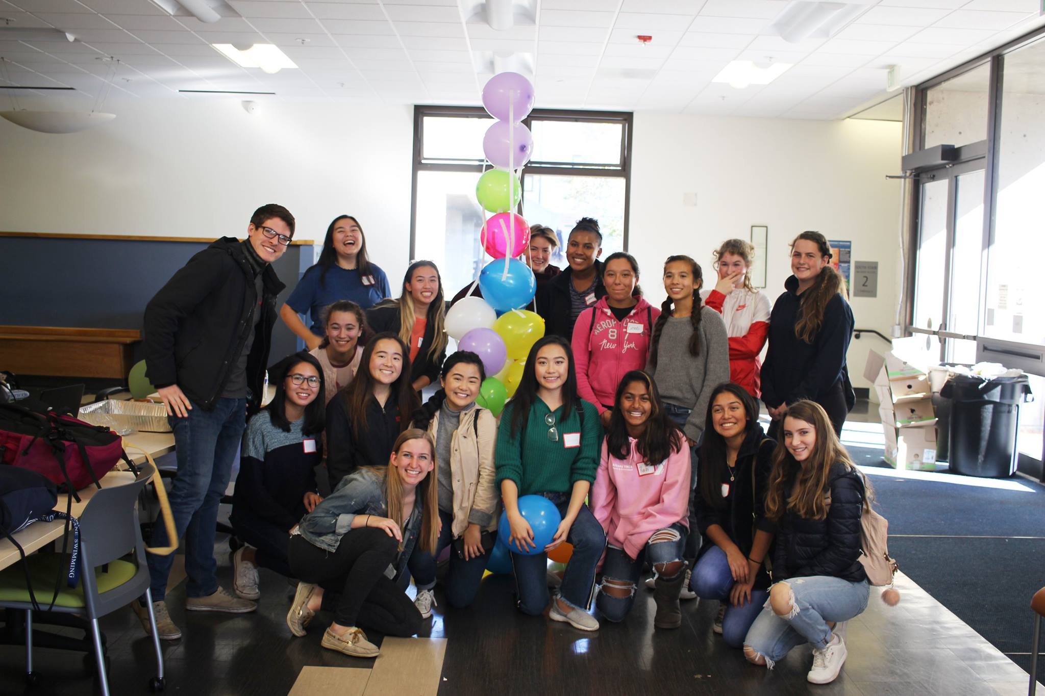 Group picture of volunteers and students holding balloons.